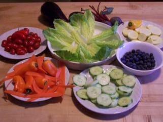 A table with bowls of vegetables and fruits on it