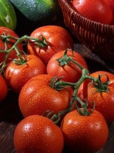 A close up of tomatoes on the vine