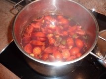 A steaming pot of red vegetables